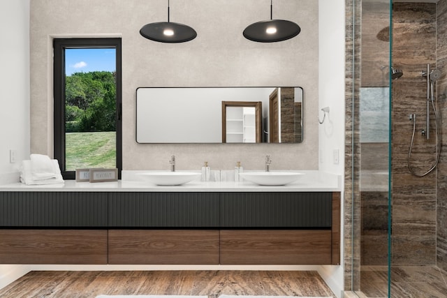 bathroom with tiled shower, vanity, and hardwood / wood-style flooring