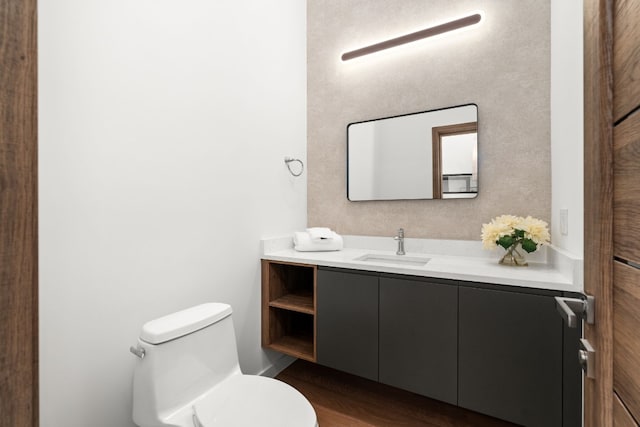 bathroom featuring toilet, vanity, and hardwood / wood-style flooring