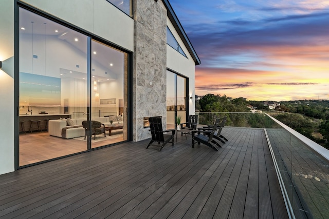 deck at dusk featuring an outdoor hangout area