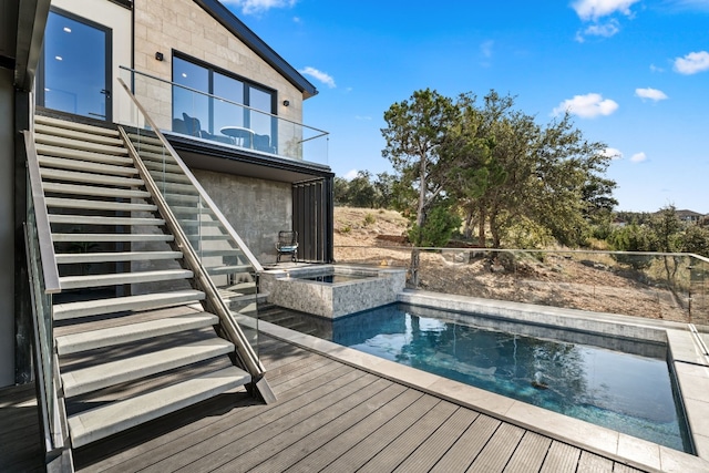 view of pool with a wooden deck and an in ground hot tub