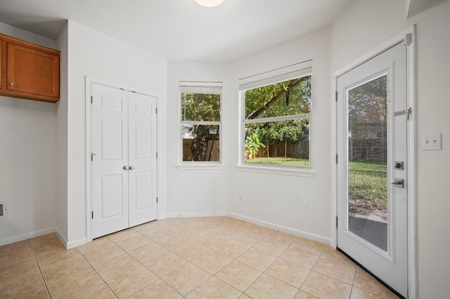 doorway to outside with light tile patterned floors