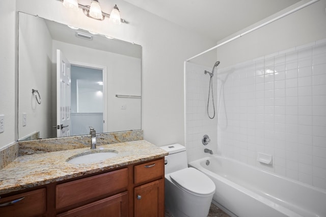 full bathroom with vanity, tiled shower / bath combo, and toilet