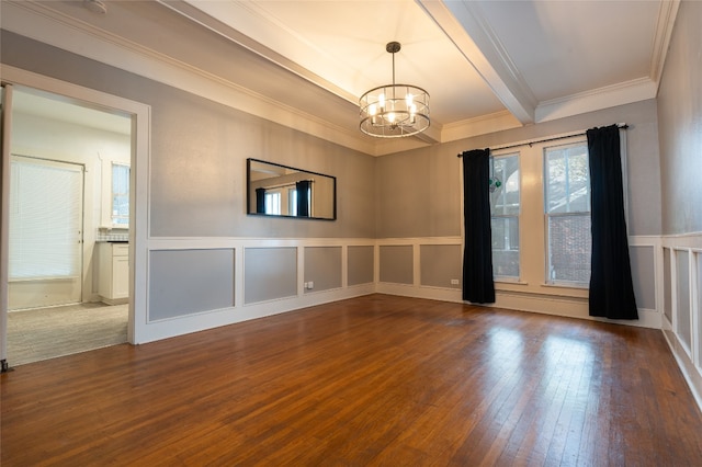 spare room featuring a chandelier, hardwood / wood-style floors, and ornamental molding