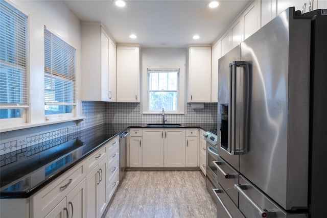 kitchen featuring sink, white cabinets, light wood-type flooring, and appliances with stainless steel finishes