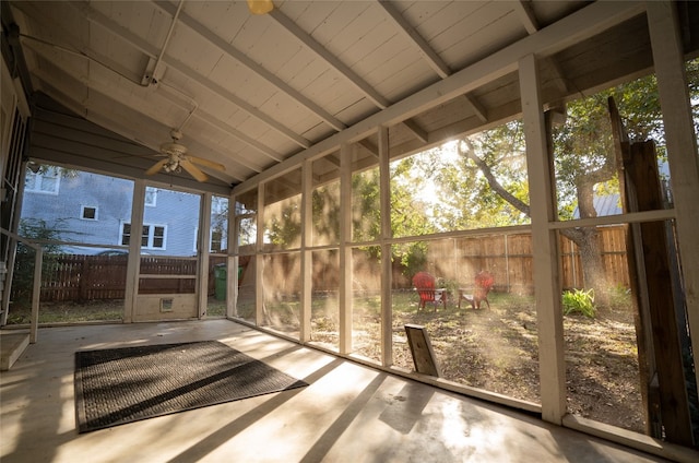 unfurnished sunroom with lofted ceiling with beams, ceiling fan, and a healthy amount of sunlight