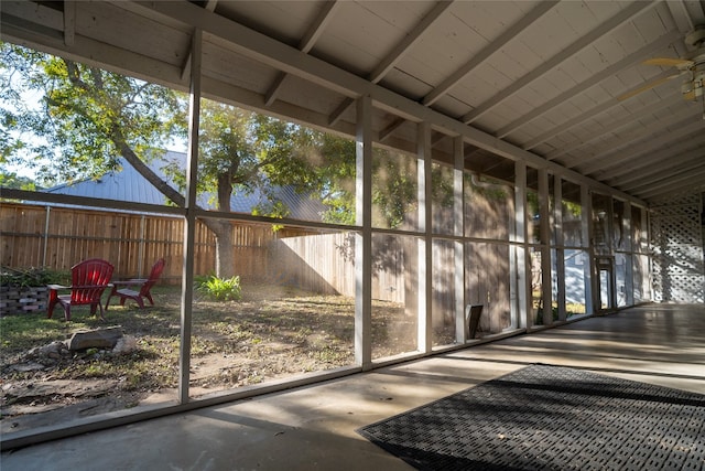 unfurnished sunroom featuring vaulted ceiling with beams