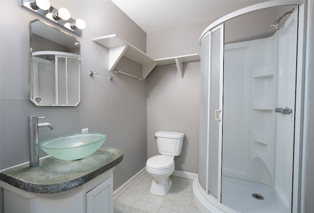 bathroom featuring tile patterned flooring, vanity, toilet, and walk in shower