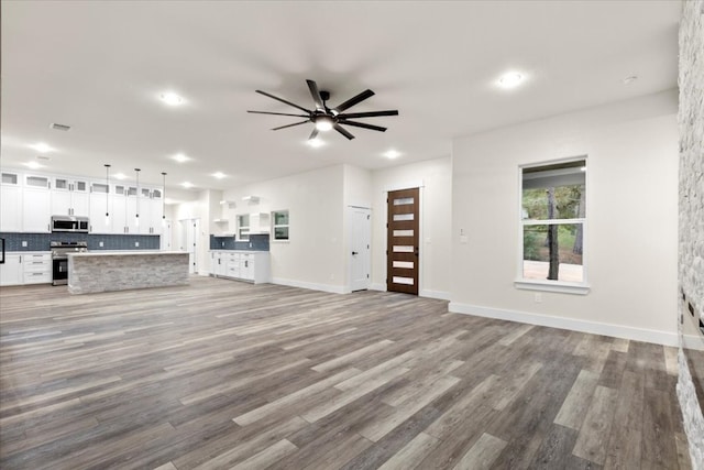 unfurnished living room featuring ceiling fan and light hardwood / wood-style floors