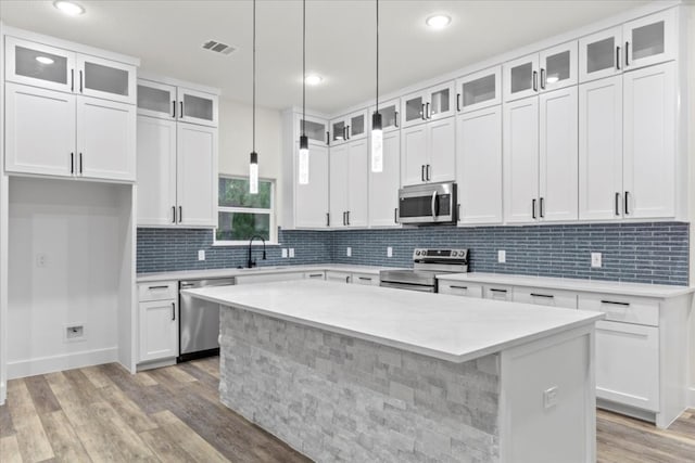 kitchen featuring white cabinets, appliances with stainless steel finishes, and a center island