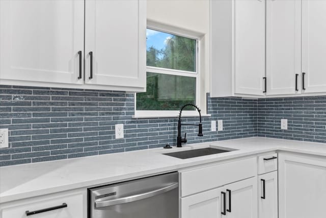 kitchen with dishwasher, white cabinets, tasteful backsplash, and sink