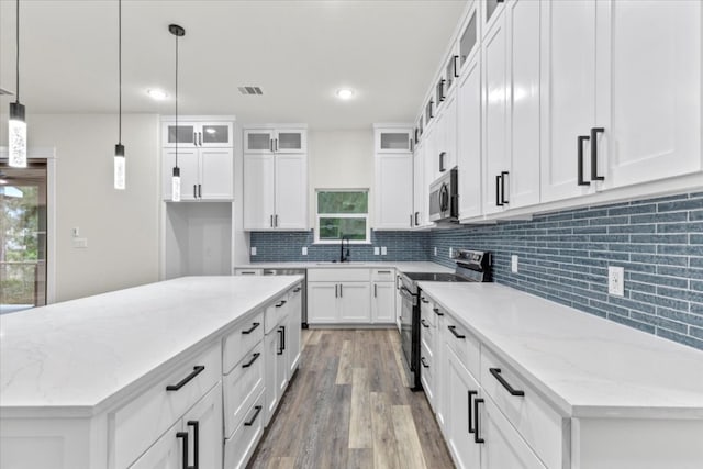 kitchen featuring pendant lighting, a center island, white cabinetry, and stainless steel appliances