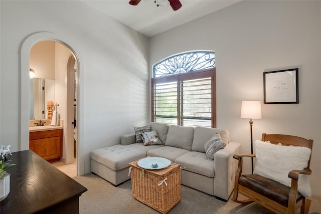 carpeted living room featuring ceiling fan and vaulted ceiling