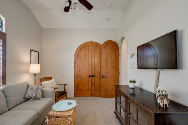 carpeted living room with ceiling fan and lofted ceiling