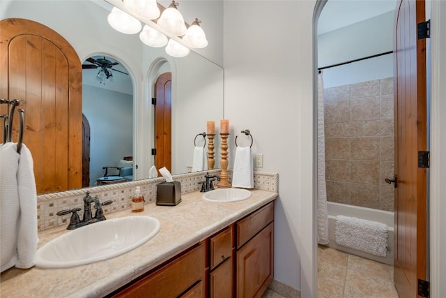 bathroom with tile patterned floors, vanity, shower / bath combo with shower curtain, ceiling fan, and decorative backsplash