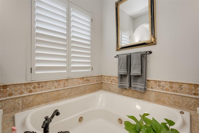 bathroom featuring plenty of natural light and tiled bath