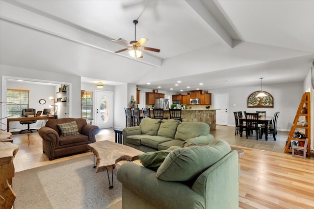 living room featuring vaulted ceiling with beams, ceiling fan, and light wood-type flooring