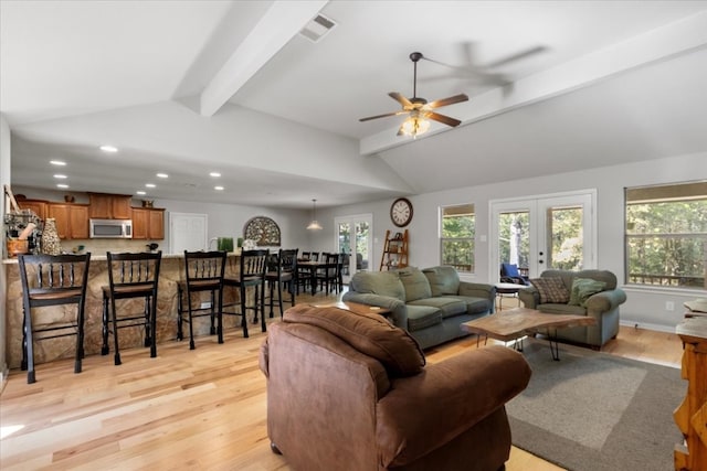 living room with vaulted ceiling with beams, ceiling fan, light wood-type flooring, and french doors