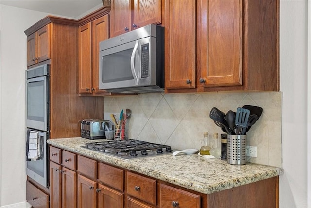 133 Blue Jack Oak Ln, Bastrop, TX 78602 - kitchen featuring appliances with stainless steel finishes, backsplash, and brown cabinetry