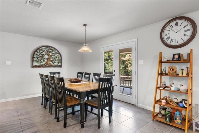 dining room featuring tile patterned flooring, french doors, visible vents, and baseboards