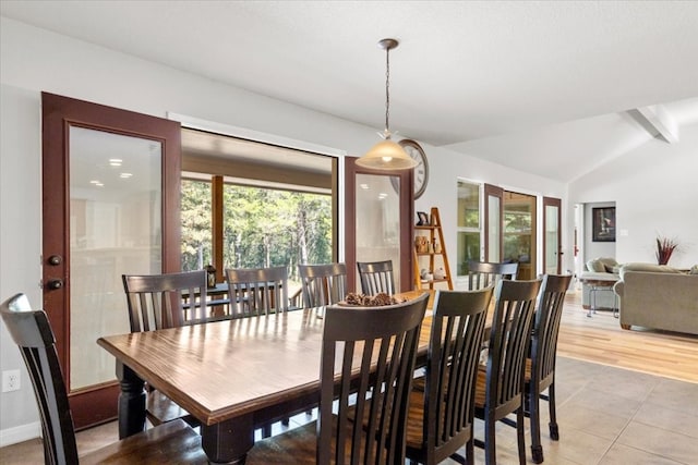 dining area with vaulted ceiling with beams, a wealth of natural light, and light hardwood / wood-style floors