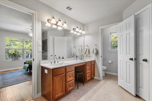 bathroom featuring vanity, a textured ceiling, ceiling fan, hardwood / wood-style floors, and toilet