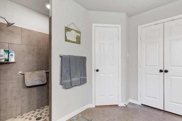 bathroom with tile patterned flooring and tiled shower