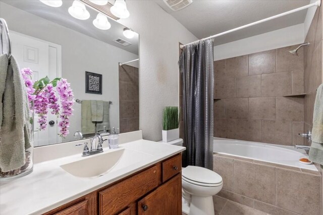 full bathroom featuring tile patterned floors, vanity, shower / bath combo, and toilet