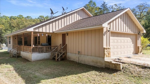 133 Blue Jack Oak Ln, Bastrop, TX 78602 - view of front of property featuring roof with shingles, covered porch, a detached garage, board and batten siding, and a front yard