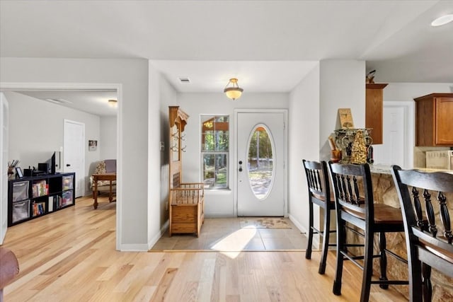 foyer entrance featuring light wood-type flooring, visible vents, and baseboards