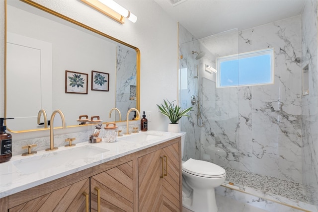 bathroom featuring vanity, toilet, and tiled shower