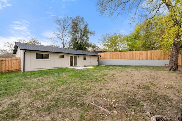 rear view of property featuring a patio and a lawn