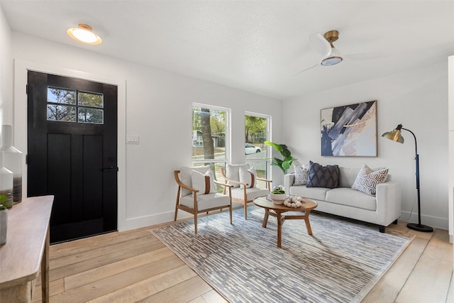 living room featuring ceiling fan and light hardwood / wood-style flooring