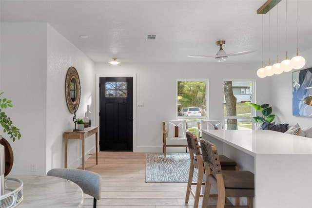 dining room featuring a textured ceiling, light wood-type flooring, and ceiling fan