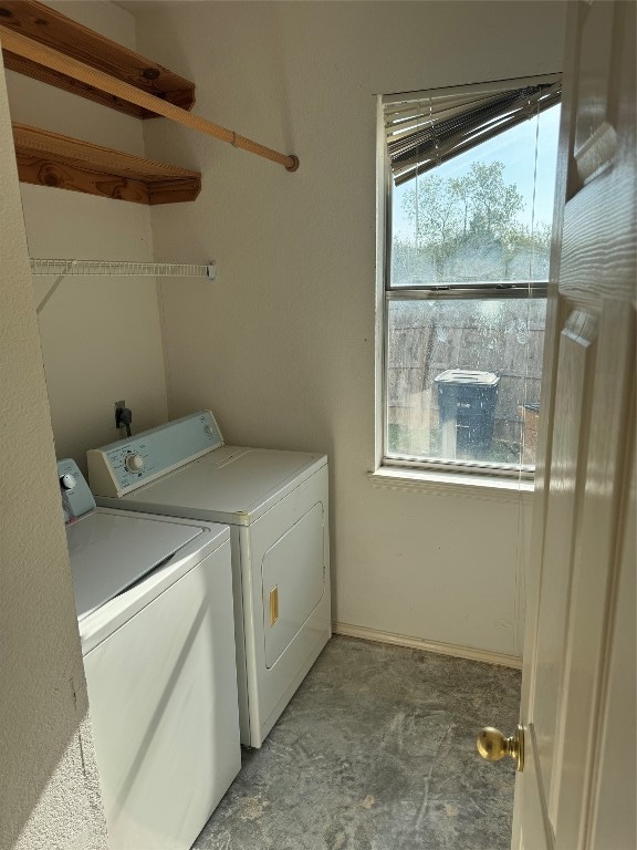 clothes washing area featuring a wealth of natural light and washer and clothes dryer