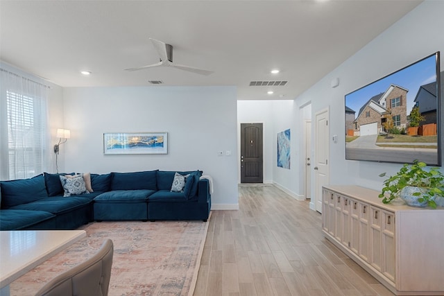 living room with ceiling fan and light hardwood / wood-style floors