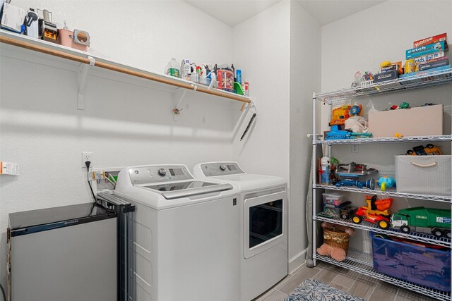 laundry room featuring separate washer and dryer and light hardwood / wood-style flooring