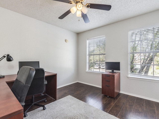 office area with a textured ceiling, dark wood-type flooring, and ceiling fan