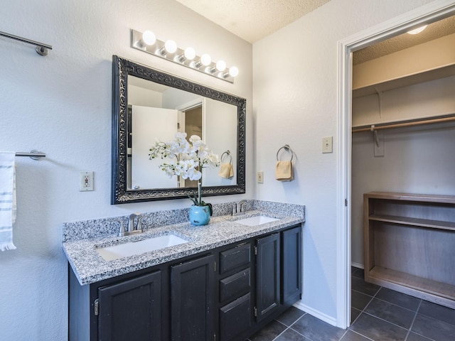 bathroom featuring vanity, tile patterned floors, and a textured ceiling