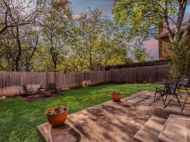 yard at dusk featuring a patio