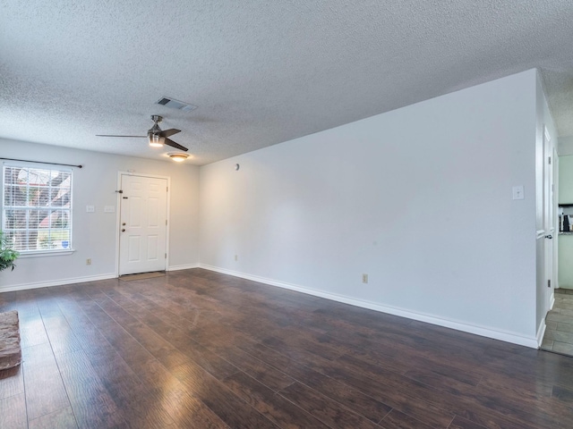 unfurnished living room featuring dark wood-type flooring, ceiling fan, and a textured ceiling