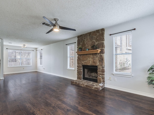 unfurnished living room featuring ceiling fan, dark wood-type flooring, a textured ceiling, and a fireplace