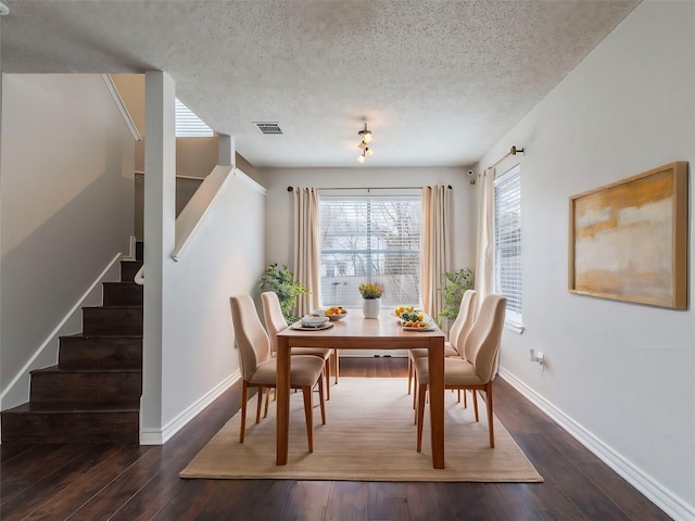 dining space featuring dark hardwood / wood-style flooring and a textured ceiling