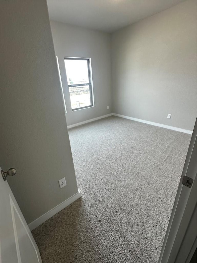 empty room featuring carpet flooring and baseboards