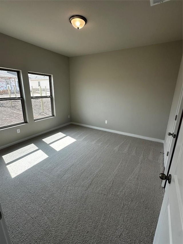 unfurnished room featuring baseboards and carpet floors