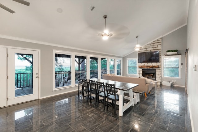 dining area featuring a fireplace, vaulted ceiling, a wealth of natural light, and ceiling fan