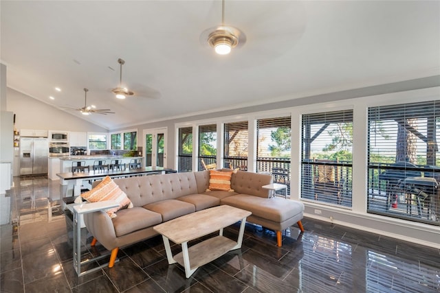 living room with ceiling fan, a healthy amount of sunlight, and vaulted ceiling