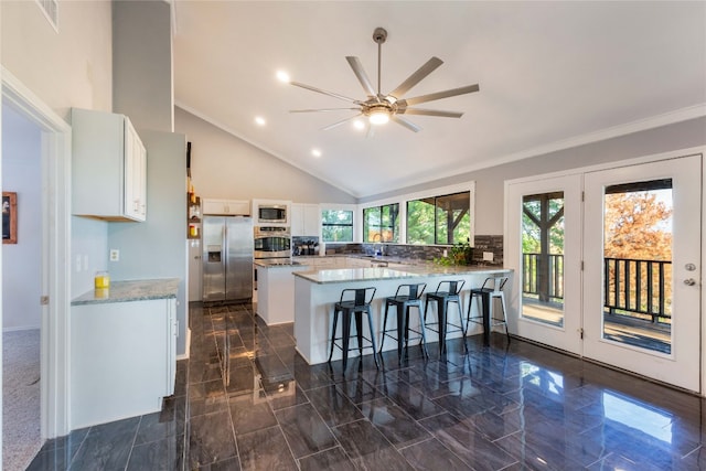 kitchen featuring white cabinetry, ceiling fan, high vaulted ceiling, kitchen peninsula, and appliances with stainless steel finishes