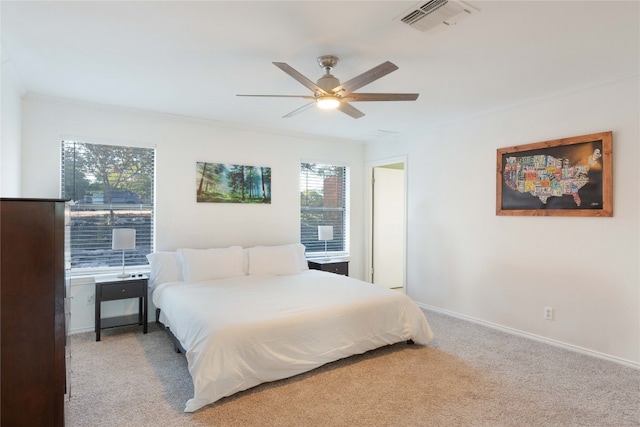 bedroom with multiple windows, ceiling fan, light colored carpet, and ornamental molding