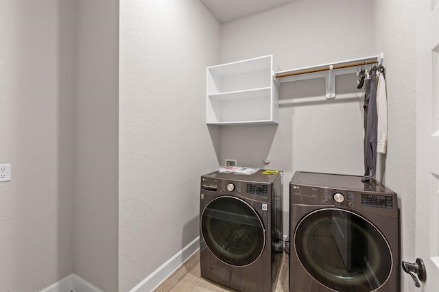 clothes washing area featuring washer and dryer and light hardwood / wood-style flooring