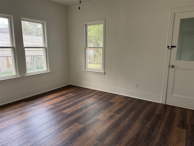 unfurnished room with dark hardwood / wood-style flooring and a wealth of natural light